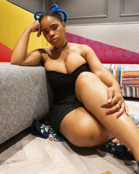 Bonolo with blue sculptural braids, seated beside a patterned sofa at FCB Africa