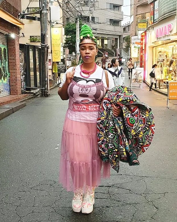 Bonolo with green braids and a pink skirt on a street in Harajuku, Tokyo
