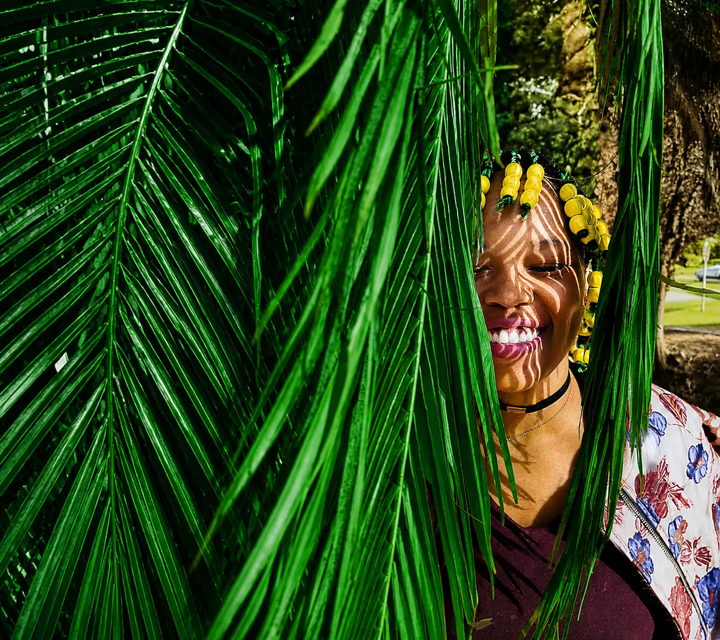 Bonolo Modise smiling through palm leaves